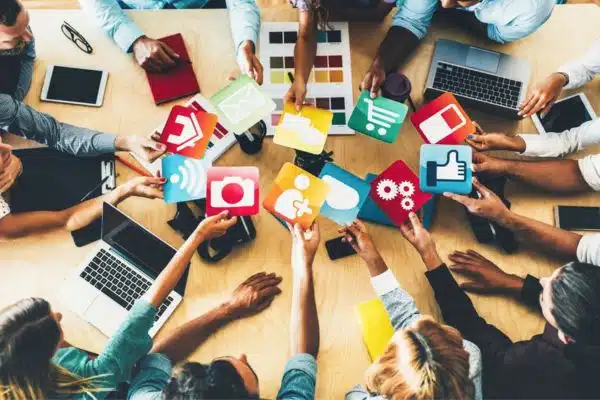 Pessoas diversas em reunião colaborativa sobre empreendedorismo social, com fundo urbano e ambiente iluminado.