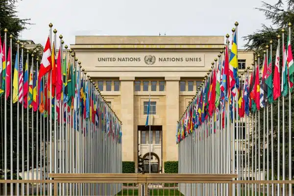 Agenda ONU 2030: Fachada do prédio da ONU e todas as bandeiras representativas de um lado e outro.
