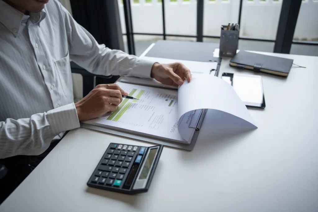 Simples Nacional com DAS, CNPJ, figura masculina analisando documentos fiscais sobre mesa, representando a tributação de micro e pequenas empresas no Brasil