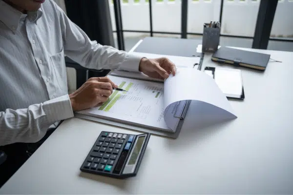 Simples Nacional com DAS, CNPJ, figura masculina analisando documentos fiscais sobre mesa, representando a tributação de micro e pequenas empresas no Brasil